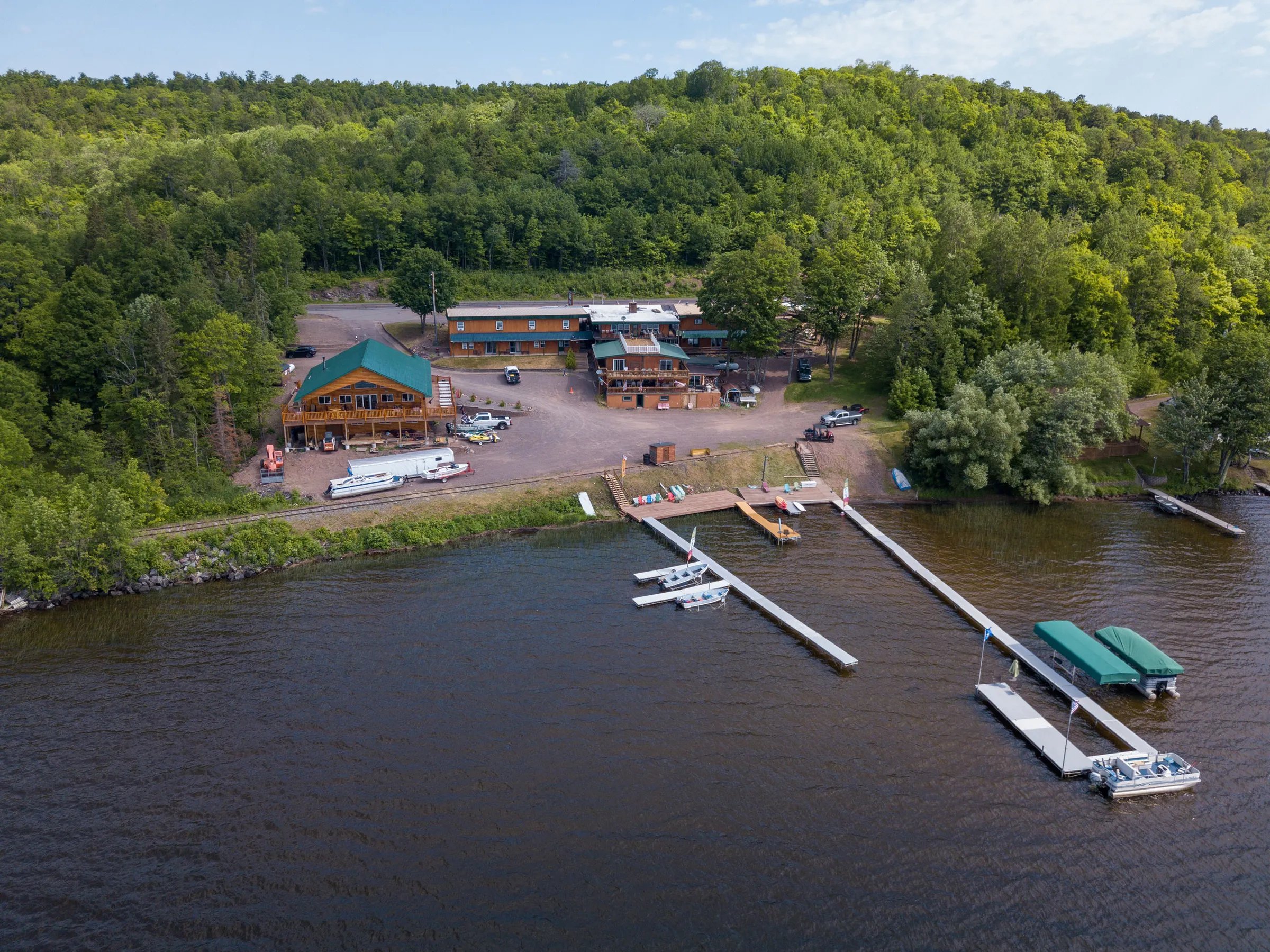 Aerial view of AJ's Lodge & Oven on Lake Gogebic with docks and surrounding forest