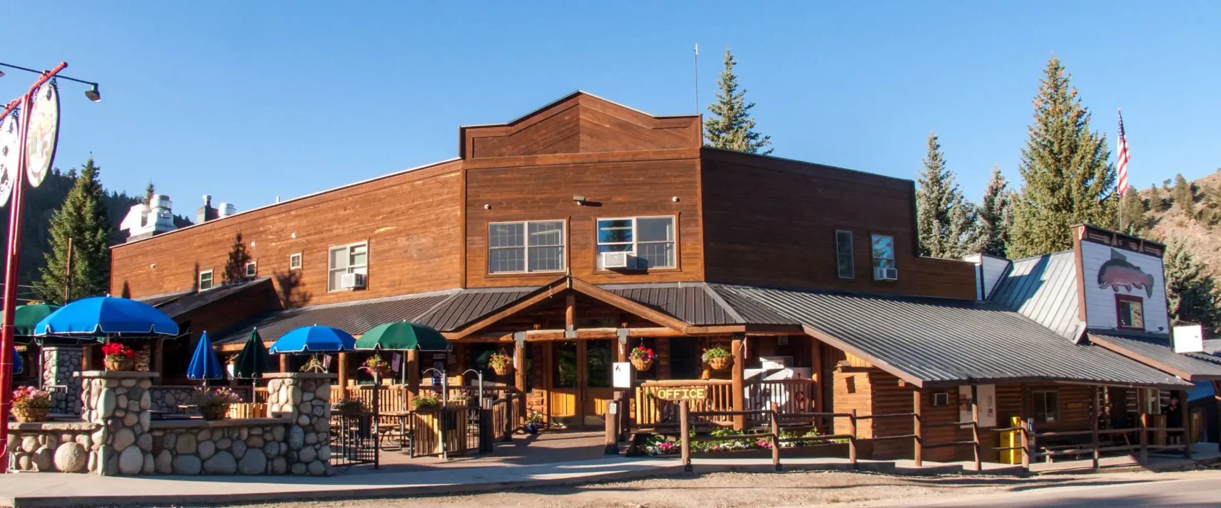 Main lodge building with a large wooden porch and outdoor seating