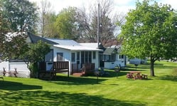 West Shore Cabins sign with a butterfly and 'Overnight and Housekeeping Cottages' text