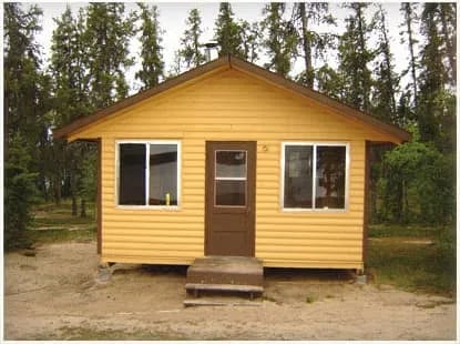 Yellow-sided Jordan Lake Outpost cabin with a brown door and windows