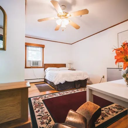 Guest bedroom with a double bed, white bedding, and a ceiling fan