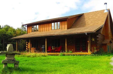 Large wooden lodge building with a wide covered porch