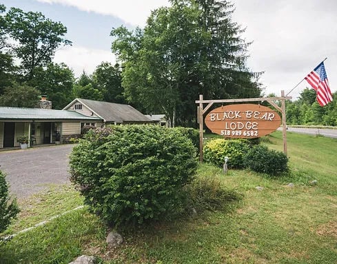 Black Bear Lodge sign and main building with an American flag flying on a sunny day