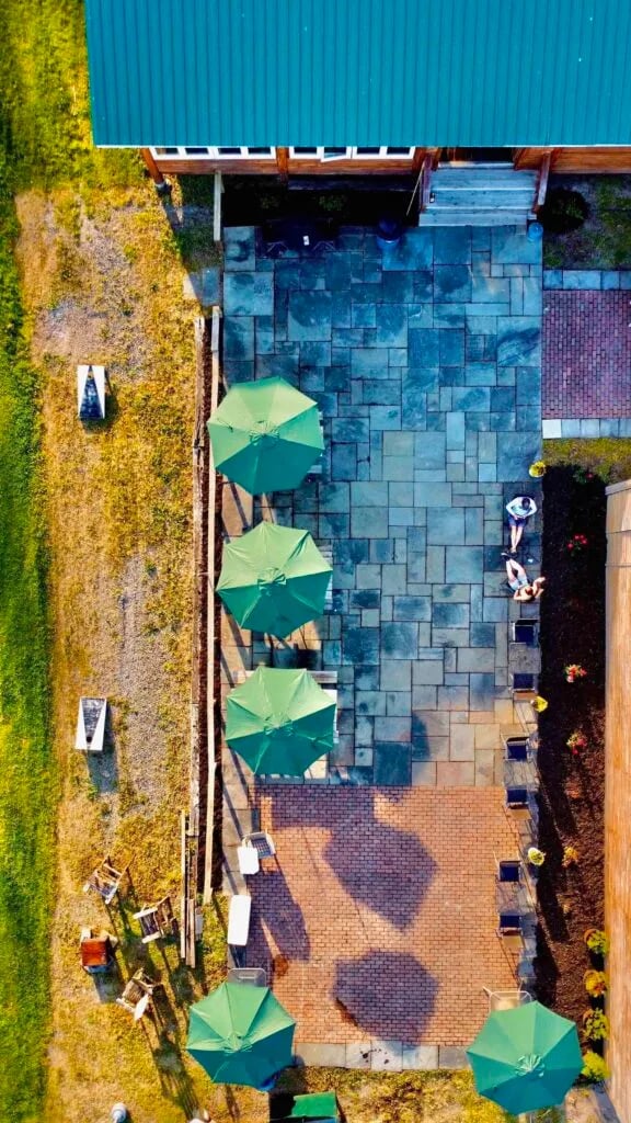Overhead view of a patio with green umbrellas next to a building