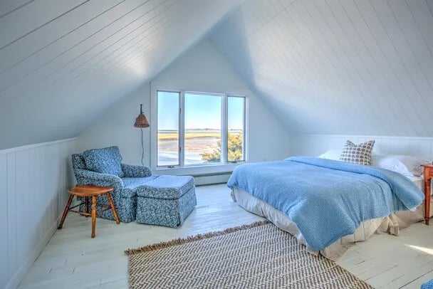 Cozy bedroom with a built-in bed, blue striped bedding, and light blue shelves
