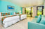 Classic room with two queen beds, a turquoise sofa, and sliding doors to a patio