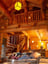 Log Cabin interior girl reading on sofa in living room with coffee table and 2nd story loft bedroom
