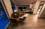Modern Mollis suite interior with a dining table, chairs, and a bed in the background.