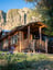 Exterior of Old Lodge log cabin with cliffs in the background and wildflowers in the foreground