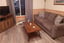 Living room with a brown sofa, wooden coffee table, and television