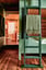 Cabin interior featuring a green bunk bed ladder and a view into an adjacent room.