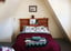 Cozy lodge room with a queen bed, sloped ceiling, and wooden headboard
