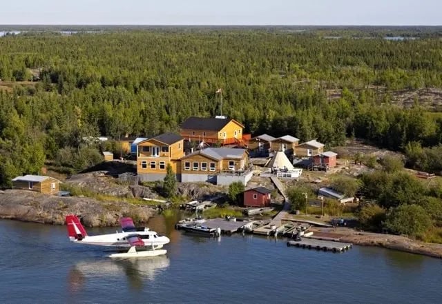 Aerial view of Trout Rock Wilderness Lodge complex with a floatplane at the dock.