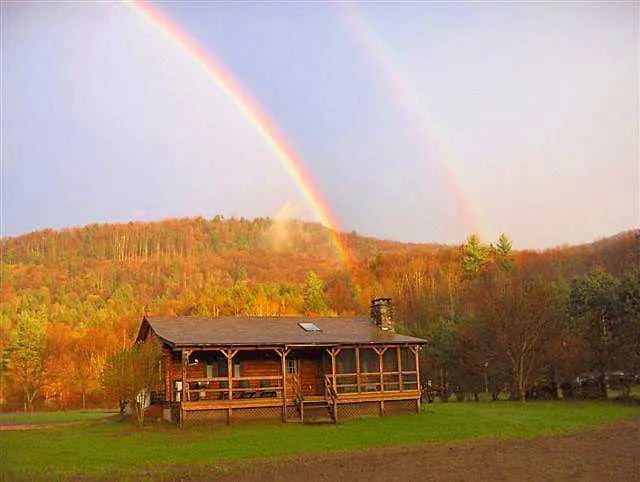 Man holding a rainbow trout by a river