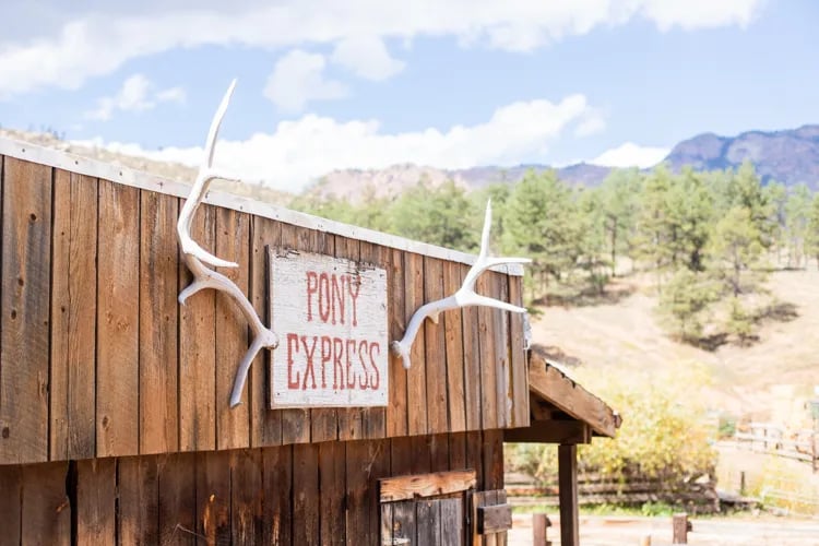 Pony Express sign with antlers mounted on a rustic wooden building facade