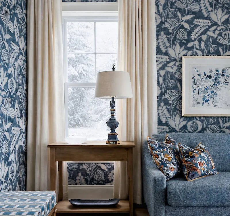 A sofa and a lamp next to a window
