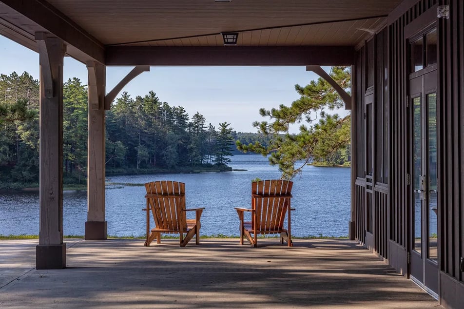 Main lodge building with green roof and a small wooden boathouse on the lake shore